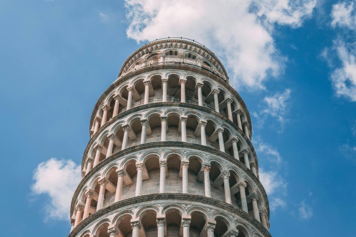 a large tall tower with a clock on the side of Leaning Tower of Pisa