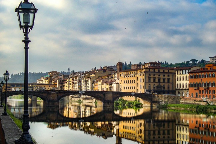a bridge over a body of water with a city in the background