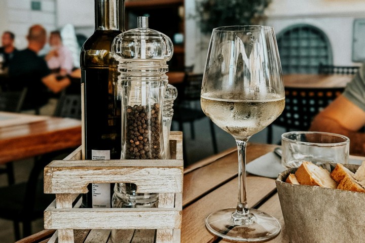 a glass of wine sitting on top of a wooden table
