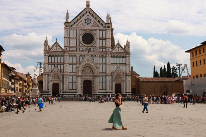 a group of people walking in front of Santa Croce, Florence