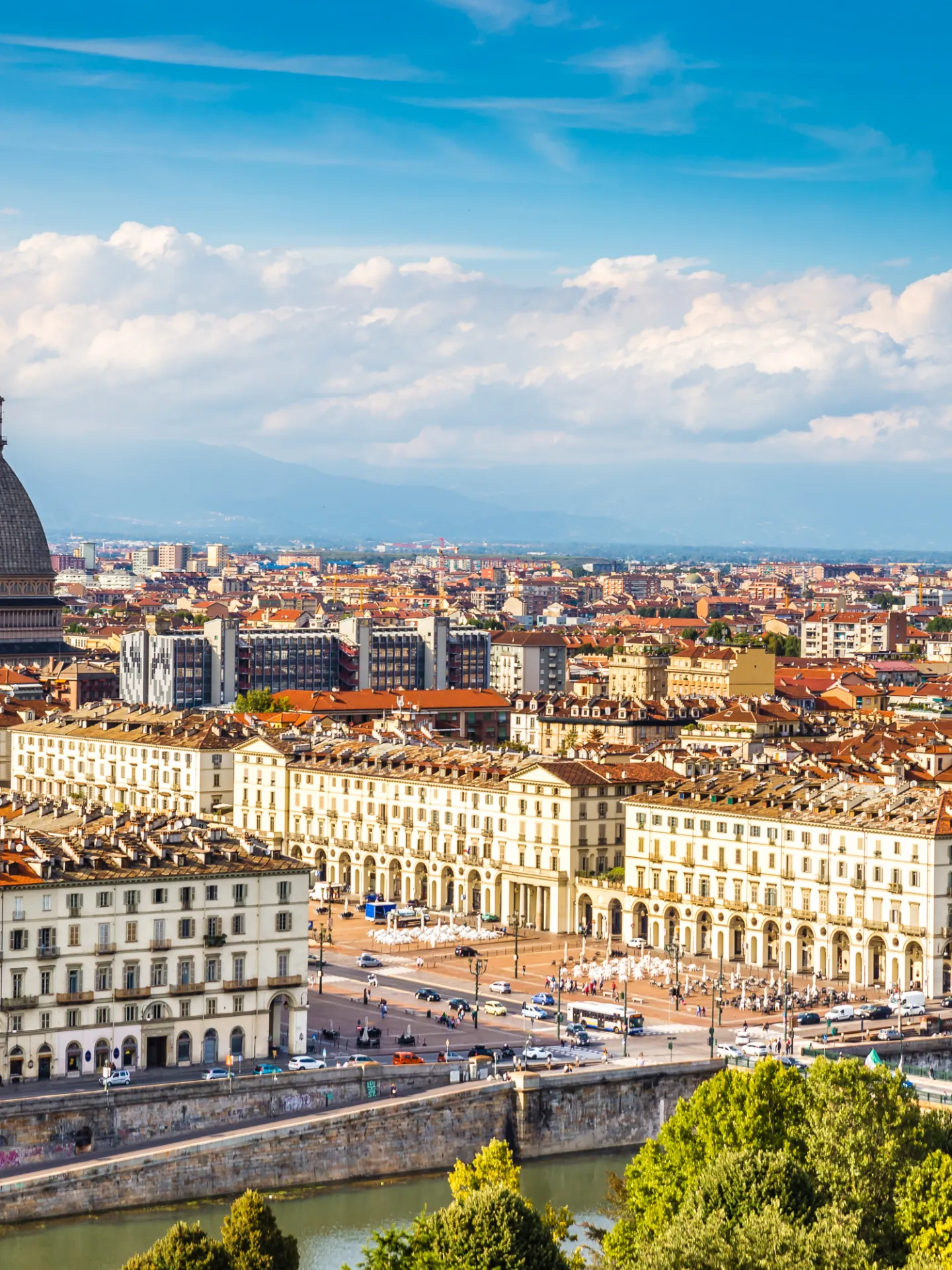 Panoramic view of Turin, Italy, featuring the Mole Antonelliana and cityscape under a blue sky.