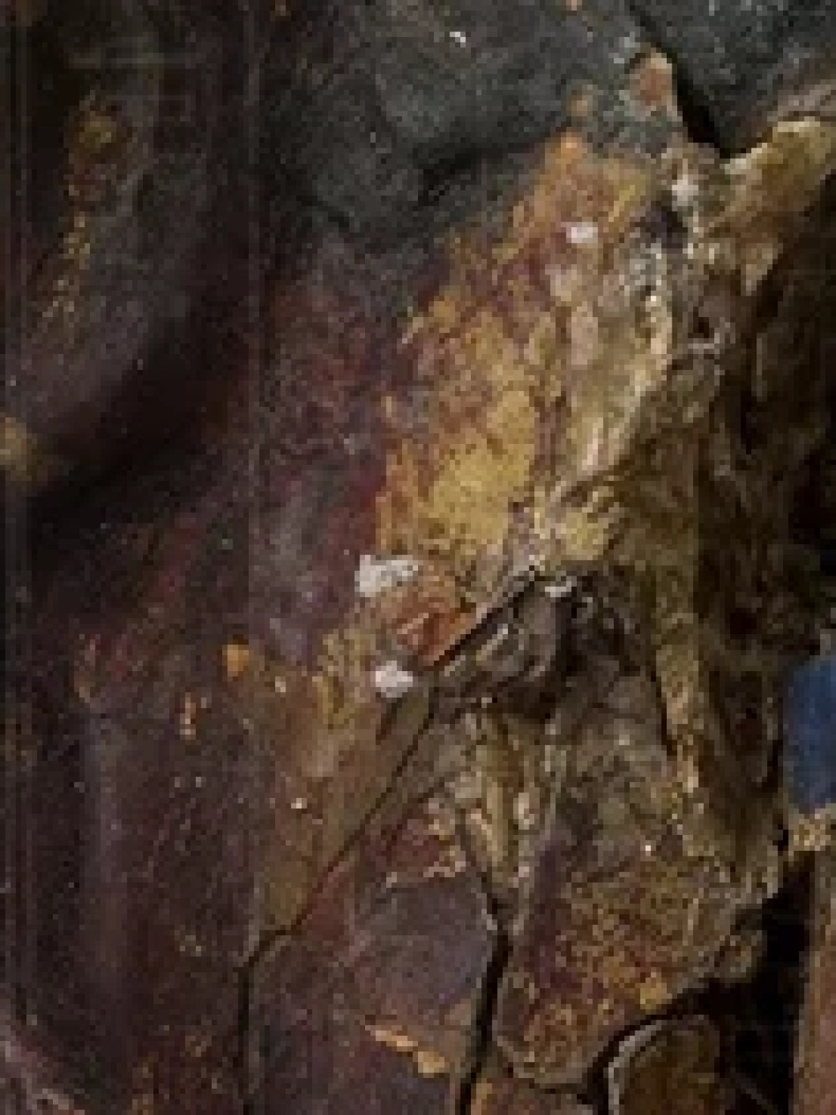 Close-up of ancient Egyptian mask with hieroglyphics in background.