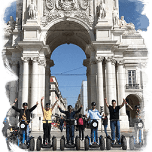 Group on Segways in front of a large stone arch with sculptures.